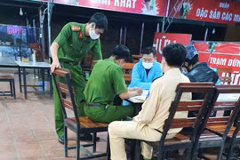 Cơ quan chức năng huyện Đạ Huoai và chốt số 1 làm việc với ông Trần Quang Vinh, người mặc đồ bảo hộ y tế. (Nguồn: thethaovanhoa)
