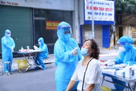 Lực lượng y tế lấy mẫu xét nghiệm sàng lọc SARS-CoV-2 cho người dân phường Nguyễn Du sáng 30/9. (Ảnh: Hoàng Hiếu/TTXVN)