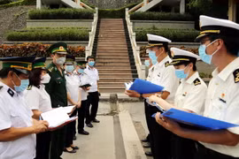 Lực lượng Kiểm dịch hai bên trao đổi tại cửa khẩu. (Ảnh: Thái Thuần/TTXVN)