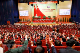 Các đại biểu biểu quyết, thông qua Nghị quyết Đại hội XIII Đảng Cộng sản Việt Nam. (Ảnh: TTXVN)