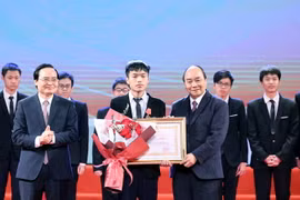 Thủ tướng Nguyễn Xuân Phúc, Chủ tịch Hội đồng Thi đua-Khen thưởng Trung ương trao tặng Huân chương lao động hạng Nhất cho em Bùi Hồng Đức, học sinh lớp 12, Trường THPT chuyên Khoa học Tự nhiên, trường Đại học Tự nhiên, Đại học Quốc gia Hà Nội. (Ảnh: Thống