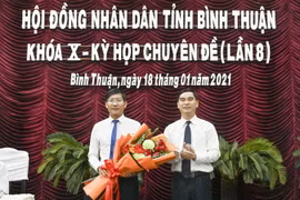 Ông Dương Văn An, Bí thư Tỉnh ủy Bình Thuận tặng hoa chúc mừng ông Lê Tuấn Phong, Chủ tịch UBND tỉnh Bình Thuận. (Ảnh: Nguyễn Thanh/TTXVN)