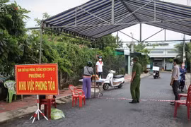 Chốt kiểm soát và hướng dẫn người dân trong khu vực phong tỏa đảm bảo các biện pháp an toàn phòng dịch. (Ảnh: Huỳnh Anh/TTXVN)