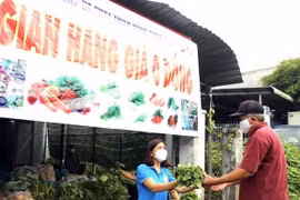 Người dân bị ảnh hưởng do dịch COVID-19 nhận rau miễn phí. (Ảnh: TTXVN phát)