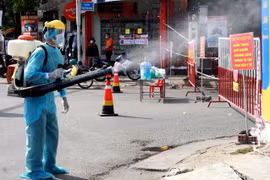 Phun thuốc tiêu độc, khử trùng tại khu vực dân cư có trường hợp dương tính với SARS-CoV-2. (Ảnh: Lê Ngọc Phước/TTXVN)