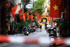 Nhân dân treo cờ Tổ quốc kỷ niệm Ngày Giải phóng Thủ đô. (Ảnh: Thành Đạt/TTXVN)