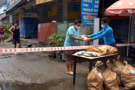 Đại diện Liên đoàn Lao động quận Bình Thạnh trao quà cho công nhân ở trọ, người nghèo trong khu phong tỏa. (Ảnh: TTXVN phát)