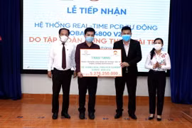 Ông Nguyễn Nam Hiền, Phó Tổng Giám đốc Tập đoàn Hưng Thịnh (thứ 2, từ phải sang) trao tượng trưng hệ thống Real-time PCR tự động cho ông Nguyễn Hồng Tâm, Phó Giám đốc HCDC, Sở Y tế Thành phố Hồ Chí Minh. (Ảnh: Xuân Khu/TTXVN)