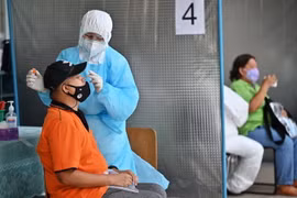 Nhân viên y tế lấy mẫu xét nghiệm COVID-19 tại Bangkok, Thái Lan. (Ảnh: AFP/TTXVN)