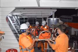 Thuyền viên tàu cứu nạn chuyên dụng SAR 413 đưa thuyền viên Khu Văn Khoan từ tàu SAR 413 lên bờ. (Nguồn: TTXVN phát)