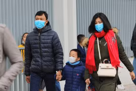 Người dân Thủ đô ra đường chơi Tết với khẩu trang y tế đề phòng virus corona. (Ảnh: Thành Đạt/TTXVN)