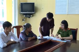 Đại úy Đặng Thị Thủy Hiền hướng dẫn các thủ tục hành chính cho người dân. (Ảnh: Phạm Kiên/TTXVN)