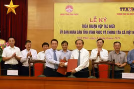 Tổng Giám đốc Thông tấn xã Việt Nam Nguyễn Đức Lợi (trái) và Phó Bí thư Tỉnh ủy, Chủ tịch UBND tỉnh Vĩnh Phúc Nguyễn Văn Trì ký thỏa thuận hợp tác. (Ảnh: Hoàng Hùng/TTXVN)