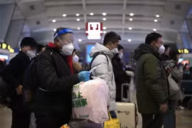 Hành khách xếp hàng chờ lên tàu tại nhà ga ở Bắc Kinh, Trung Quốc. (Ảnh: AFP/TTXVN)