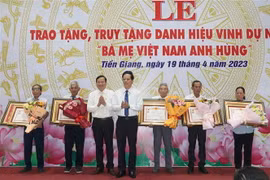 Lãnh đạo tỉnh Tiền Giang trao tặng danh hiệu cao quý Bà mẹ Việt Nam Anh hùng cho đại diện gia đình các mẹ. (Ảnh: Minh Trí/TTXVN)