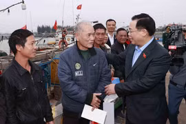 Chủ tịch Quốc hội Vương Đình Huệ tặng quà cho ngư dân tại Khu neo đậu tàu thuyền Cửa Phú. (Ảnh: Doãn Tấn/TTXVN)