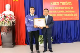Chủ tịch Ủy ban Nhân dân thành phố Đà Lạt Tôn Thiện San tặng giấy khen cho tài xế taxi Nguyễn Duy Phin. (Ảnh: Quốc Hùng/TTXVN)