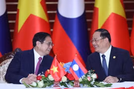 Thủ tướng Phạm Minh Chính và Thủ tướng Lào Sonexay Siphandone trao đổi tại lễ ký các văn kiện hợp tác giữa hai nước Việt Nam-Lào. (Ảnh: Dương Giang/TTXVN)