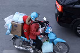 Dễ dàng bắt gặp chiếc xe máy chở cồng kềnh đồ đạc trên đường. (Ảnh: Hoàng Hiếu/TTXVN)