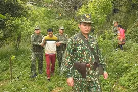 Lực lượng Bộ đội Biên phòng áp giải một đối tượng có hành vi mua bán người. (Ảnh: TTXVN phát)