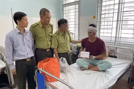 Lãnh đạo Chi cục Kiểm lâm Đồng Nai thăm hỏi, động viên kiểm lâm viên của Vườn Quốc gia Cát Tiên tại bệnh viện. (Ảnh: TTXVN phát)