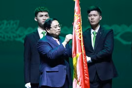 Thủ tướng Phạm Minh Chính gắn Danh hiệu Anh hùng Lao động lên cờ truyền thống Ngân hàng thương mại cổ phần Ngoại thương Việt Nam. (Ảnh: Dương Giang/TTXVN)