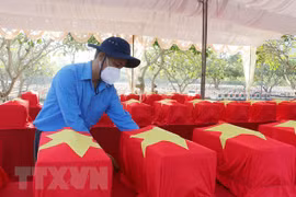 Đưa hài cốt liệt sỹ ra nơi cải táng. (Ảnh: Công Mạo/TTXVN)