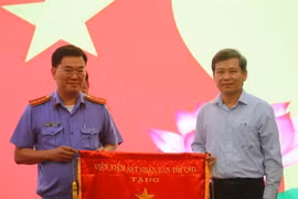 Viện trưởng Lê Minh Trí trao cờ thi đua cho Phòng thực hành quyền công tố và kiểm sát điều tra án kinh tế-chức vụ - Phòng 3 Viện Kiểm sát Nhân dân TP.HCM. (Ảnh: Thành Chung/TTXVN)