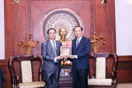 Bí thư Thành ủy Thành phố Hồ Chí Minh Nguyễn Văn Nên tặng phẩm lưu niệm cho ông Khampheng Vilaphanh. (Ảnh: Xuân Khu/TTXVN)