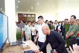 Các đại biểu tham quan mô hình ứng dụng căn cước công dân gắn chip điện tử, VNEID phục vụ kiểm soát an ninh và chấm công tại Công ty Cổ phần Ximăng Xuân Thành. (Ảnh: Nguyễn Chinh/TTXVN)