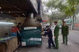 Lực lượng chức năng phường Giảng Võ (Ba Đình) xử lý cửa hàng kinh doanh ăn uống vi phạm vỉa hè trên địa bàn. (Ảnh: Mạnh Khánh/TTXVN)