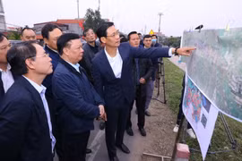 Bí thư Thành ủy Hà Nội Đinh Tiến Dũng kiểm tra thực địa tại địa điểm chân cầu Hồng Hà, khu vực đê Hữu Hồng, xã Hồng Hà, huyện Đan Phượng. (Ảnh: Văn Điệp/TTXVN)