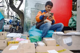 Các shipper (người giao hàng) đang 'bơi' trong đơn hàng trong những ngày cuối năm. (Ảnh: Việt Anh/Vietnam+)