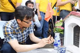 Phó Thủ tướng Vũ Đức Đam dùng thử ứng dụng thông tin điện tử về liệt sỹ, mộ liệt sỹ và nghĩa trang liệt sỹ trên điện thoại. (Ảnh: Dương Giang/TTXVN)