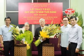 Bí thư Thành ủy Hà Nội Hoàng Trung Hải trao Huy hiệu 70 năm tuổi Đảng cho nguyên Phó Trưởng ban Tổ chức Trung ương Nguyễn Đình Hương và bà Trương Thị Xin, nguyên Giám đốc Xí nghiệp may Chiến Thắng. (Ảnh: TTXVN)