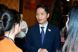 Phóng viên phỏng vấn Bộ trưởng Bộ Công Thương Trần Tuấn Anh trong giờ giải lao. (Ảnh: Thống Nhất/TTXVN)