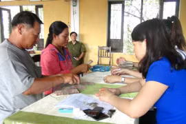 Người dân xã Lộc Điền nhận tiền bồi thường. (Ảnh: Tường Vi/TTXVN)