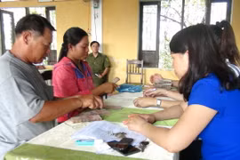 Người dân xã Lộc Điền nhận tiền bồi thường. (Ảnh: Tường Vi/TTXVN)