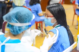 Học sinh thực hiện việc tiêm chủng. (Ảnh: Văn Dũng/TTXVN)