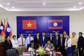 Lãnh đạo TTXVN và KPL ký Biên bản bàn giao trang thiết bị, kỹ thuật. (Ảnh: Phạm Kiên/TTXVN)