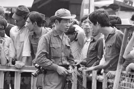 Phóng viên Đinh Quang Thành của Việt Nam Thông tấn xã gặp gỡ, thu thập thông tin từ người dân Sài Gòn trong ngày giải phóng, 30/4/1975. (Ảnh: TTXVN)