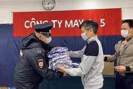 Đại diện Công an Thành Phố Plavsk nhận khẩu trang từ Công ty may 9-5. (Ảnh: Duy Trinh/TTXVN)