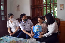 Thượng tá Nguyễn Văn Hiển - Phó Chính uỷ Vùng Cảnh sát biển 1 - tặng quà cho Mẹ Việt Nam Anh hùng Nguyễn Thị Cẩm, 94 tuổi, có hai con liệt sỹ tại khu 5, thị trấn Tiên Lãng, Hải Phòng. (Ảnh: TTXVN)