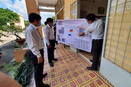 Lãnh đạo Ủy ban Nhân dân tỉnh Tiền Giang và Sở Giáo dục và Đào tạo kiểm tra sơ đồ bố trí các phòng thi. (Ảnh: Hữu Chí/TTXVN)