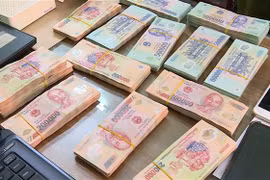 Tang vật và tiền mặt lực lượng chức năng thu giữ tại nhà các đối tượng. (Ảnh: Đinh Tuấn/TTXVN)