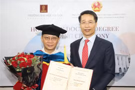 Tổng Lãnh sự Việt Nam tại Hong Kong Phạm Bình Đàm (phải) thay mặt Trường Đại học Hà Nội trao bằng Tiến sỹ danh dự cho ông Lâm Kiến Trung, Chủ tịch Tập đoàn Zhang Yang Group HoldingsLtd Hong Kong. (Ảnh: TTXVN)