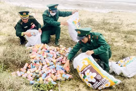 Cán bộ, chiến sỹ Đồn Biên phòng Lý Hòa thu gom thuốc lá trôi dạt tại bờ biển xã Hải Phú. (Nguồn: bienphong.com.vn)