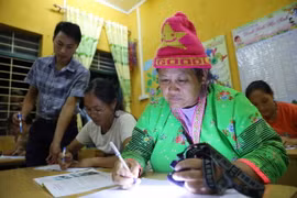 Chị Vàng Thị Của (phải) ở bản Cà Là Pá, xã Leng Su Sìn, tuy không phải là học viên chính thức nhưng vẫn xin tự nguyện đi học xóa mù chữ. (Ảnh: Trung Kiên/TTXVN)