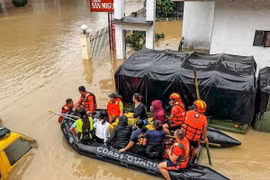 Lực lượng cứu hộ sơ tán các nạn nhân tại hiện trường ngập lụt sau bão Trami, ngày 24/10. (Ảnh: THX/TTXVN)