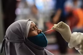 Nhân viên y tế lấy mẫu xét nghiệm COVID-19 tại Jakarta, Indonesia. (Ảnh: THX/TTXVN)